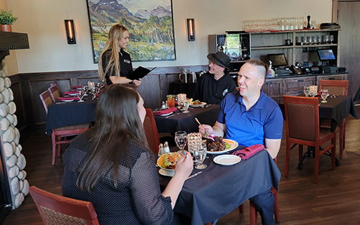 A photo from inside a tent looking out onto the campfire and forest on a summer afternoon.